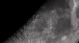 An extreme close-up of the moon shows craters near the shaded edge of the body's day and night sides. Catharina, Cyrillus and Theophilus craters are labeled just above Mare Neclaris, also labeled.