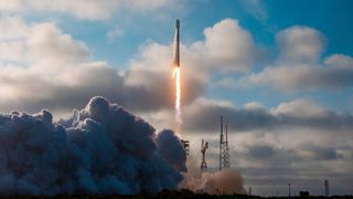 a white rocket lifts off under a cloudy sky