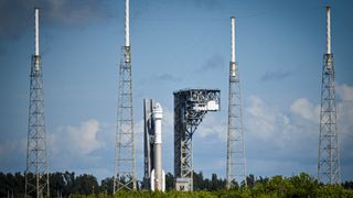 a rocket at a launch pad surrounded by towers