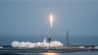 a rocket launches above a plume of smoke