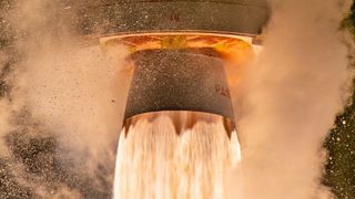 a massive plume of fire shoots out of a rocket engine